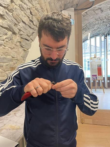 Un homme utilisant un cutter pour enlever de la matière sur les branche d'une monture